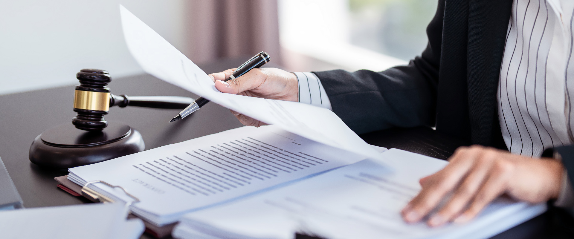 Lawyer businesswoman holding document to reading lawsuit and checking about financial business data while analysis about legislation agreement and terms data of business contract in law firm